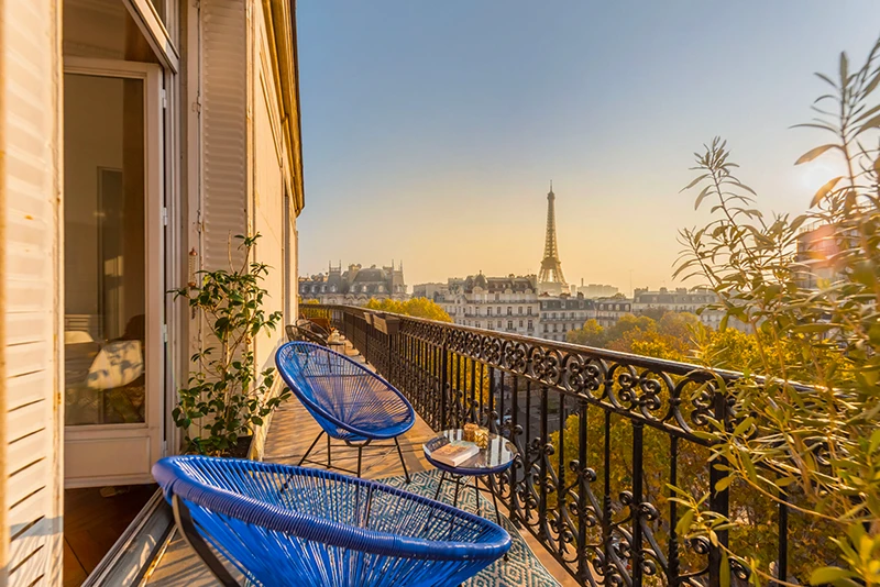 balcon parisien avec deux fauteuils et une vue dégagée sur la tour eiffel